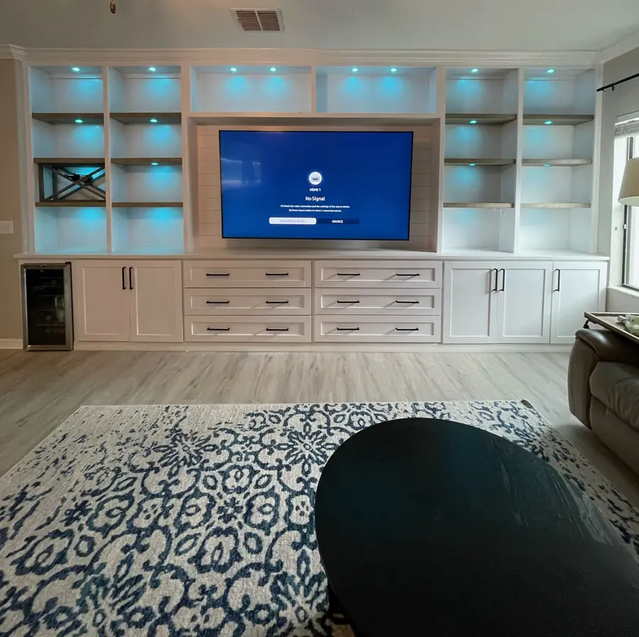 White built-in entertainment wall with lit shelving by Frost Custom Carpentry in Tampa, FL